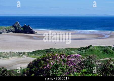 Erhöhter Blick auf Three Cliffs Bay in The Gower, einer atemberaubenden Sandbucht an der Küste von Wales. Drei große Felsen stehen am östlichen Rand dieses Stauses Stockfoto