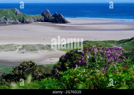 Erhöhter Blick auf Three Cliffs Bay in The Gower, einer atemberaubenden Sandbucht an der Küste von Wales. Drei große Felsen stehen am östlichen Rand dieses Stauses Stockfoto