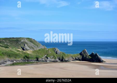 Erhöhter Blick auf Three Cliffs Bay in The Gower, einer atemberaubenden Sandbucht an der Küste von Wales. Drei große Felsen stehen am östlichen Rand dieses Stauses Stockfoto