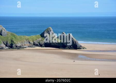 Erhöhter Blick auf Three Cliffs Bay in The Gower, einer atemberaubenden Sandbucht an der Küste von Wales. Drei große Felsen stehen am östlichen Rand dieses Stauses Stockfoto