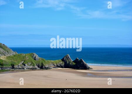 Erhöhter Blick auf Three Cliffs Bay in The Gower, einer atemberaubenden Sandbucht an der Küste von Wales. Drei große Felsen stehen am östlichen Rand dieses Stauses Stockfoto