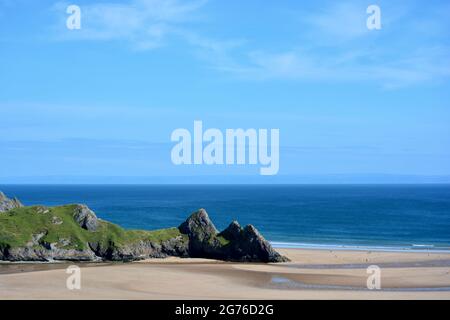 Erhöhter Blick auf Three Cliffs Bay in The Gower, einer atemberaubenden Sandbucht an der Küste von Wales. Drei große Felsen stehen am östlichen Rand dieses Stauses Stockfoto