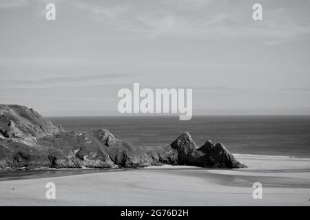 Erhöhter Blick auf Three Cliffs Bay in The Gower, einer atemberaubenden Sandbucht an der Küste von Wales. Drei große Felsen stehen am östlichen Rand dieses Stauses Stockfoto