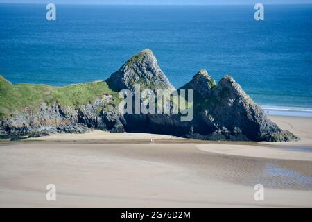 Erhöhter Blick auf Three Cliffs Bay in The Gower, einer atemberaubenden Sandbucht an der Küste von Wales. Drei große Felsen stehen am östlichen Rand dieses Stauses Stockfoto