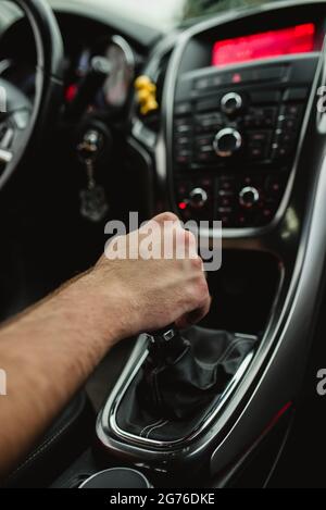 Während der Fahrt hält der Fahrer seine Hand auf dem Schalthebel Stockfoto