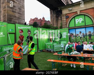 Ein Fan, der auf einen Aussichtspunkt geklettert ist, um vor dem UEFA Euro 2020 Finale zwischen Italien und England die Großleinwand der PaddyPark Fanzone am Fluss Tyne in Newcastle zu sehen. Bilddatum: Sonntag, 11. Juli 2021. Stockfoto