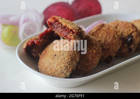 Luftgebratene Rote-Beete-Koteletts. Serviert mit Zwiebeln. Aufgenommen auf weißem Hintergrund Stockfoto