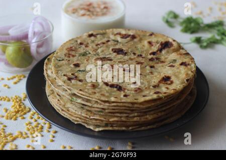 Ein proteinreiches indisches Flachbrot mit Vollkorn und Linsen. In vielen Teilen Indiens ist das Moong dal Paratha im Volksmund auch bekannt. Aufgenommen auf weißem Hintergrund. Stockfoto