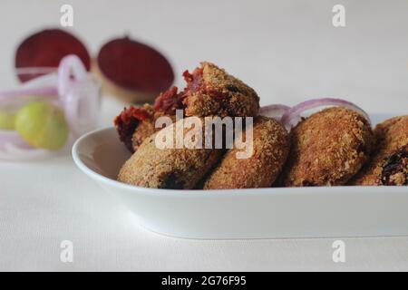 Luftgebratene Rote-Beete-Koteletts. Serviert mit Zwiebeln. Aufgenommen auf weißem Hintergrund Stockfoto