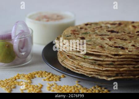 Ein proteinreiches indisches Flachbrot mit Vollkorn und Linsen. In vielen Teilen Indiens ist das Moong dal Paratha im Volksmund auch bekannt. Aufgenommen auf weißem Hintergrund. Stockfoto