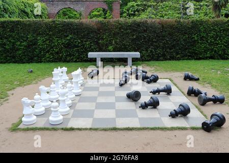 LONDON, VEREINIGTES KÖNIGREICH - 09. Jun 2021: Ein kreatives großes Schachbrett mit verstreuten schwarzen Stücken in Holland Park, London, Vereinigtes Königreich Stockfoto