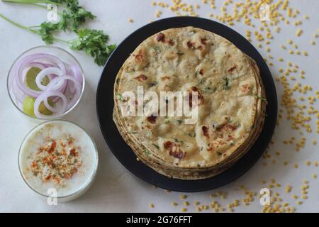 Ein proteinreiches indisches Flachbrot mit Vollkorn und Linsen. In vielen Teilen Indiens ist das Moong dal Paratha im Volksmund auch bekannt. Aufgenommen auf weißem Hintergrund. Stockfoto