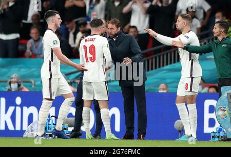 Der englische Mason Mount spricht mit Manager Gareth Southgate, als Declan Rark (links) während des UEFA Euro 2020 Finales im Wembley Stadium, London, durch Jordan Henderson ersetzt wird. Bilddatum: Sonntag, 11. Juli 2021. Stockfoto