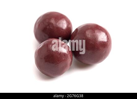 Dunkelrot beschichtete, mit Schokolade überzogene Trockenfrüchte auf weißem Hintergrund Stockfoto
