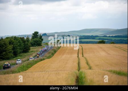 Pewsey, England. 11. Juli 2021. Das Feld passiert Weizenfelder bei den British Cycling Junior National Road Race Championships. Kredit: David Partridge/Alamy Live Nachrichten Stockfoto