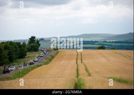 Pewsey, England. 11. Juli 2021. Das Feld passiert Weizenfelder bei den British Cycling Junior National Road Race Championships. Kredit: David Partridge/Alamy Live Nachrichten Stockfoto