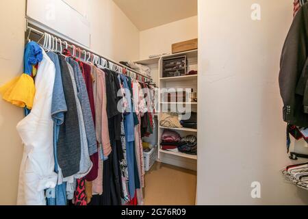 Kleiner begehbarer Schrank mit Kleiderstange und Regalen Stockfoto