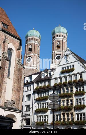 Die Türme der Frauenkirche hinter den Häusern der pdestrianischen Zone im Zentrum von München Stockfoto