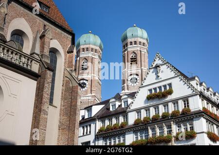 Die Türme der Frauenkirche hinter den Häusern der pdestrianischen Zone im Zentrum von München Stockfoto