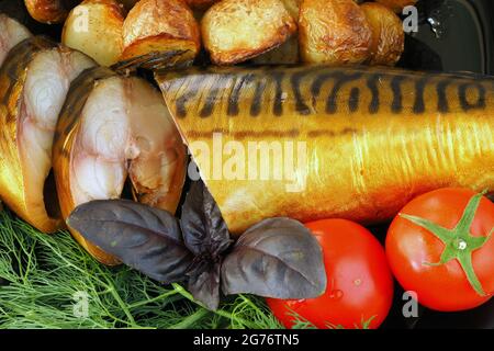 Geräucherte Makrele auf einem Teller mit Tomaten und Dillkartoffeln. Stockfoto