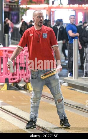 Broad Street, Birmingham 11. Juli 2021 Fans zwickten sich zusammen, nachdem England aus dem EM 2020-Finale mit Italien, das bei den Strafen gewann, abstürzte und es 56 Jahre lang verletzt hatte. Die Fans sprangen aus Pubs und Bars auf die Broad Street im Stadtzentrum von Birmingham, als die Polizei Linien bildete. Viele Fans sahen niedergeschlagen aus, eine Frau sah verloren aus, als sie durch Brunnen ging. Eine Rauchgranate wurde ebenfalls gestartet, als die Polizei versuchte, Unterstützer zu beruhigen, obwohl ein englisches Kit mit Ventilator eine Wodka-Flasche in die Luft winkte, bevor die Polizei drohte, Gas zu verwenden, wenn er es nicht fallen ließ. Der Mann wurde dann eingesperrt. Stockfoto