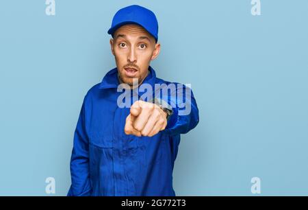 Kahlköpfiger Mann mit Bart, der einen Overall trägt, zeigt unzufrieden und frustriert auf die Kamera, wütend und wütend auf dich Stockfoto