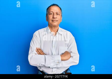 Mittelalter indischer Mann mit gekreuzten Armen Geste entspannt mit ernstem Gesichtsausdruck. Einfaches und natürliches Betrachen der Kamera. Stockfoto