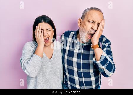 Hispanische Vater und Tochter in legerer Kleidung gähnend müde, bedeckt Halbgesicht, Auge und Mund mit der Hand. Gesicht schmerzt bei Schmerzen. Stockfoto