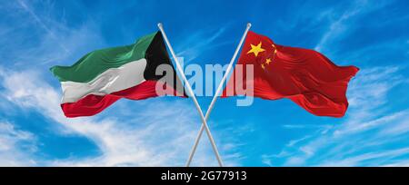 Flaggen von China und Kuwait winken im Wind auf Fahnenmasten gegen den Himmel mit Wolken am sonnigen Tag. Ein Symbol für die Beziehung, den Dialog zwischen zwei Ländern Stockfoto