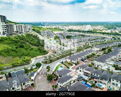 Eine Luftaufnahme der Häuser einer Wohnanlage in Guayaquil, Ecuador. Sonniger Tag. Dächer, Spielplätze, Bäume, Häuser bauen nebeneinander. Stockfoto