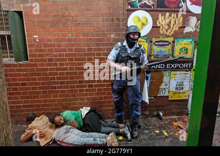 Johannesburg, Südafrika. Juli 2021. Ein Polizist verhafte Demonstranten am 11. Juli 2021 in Johannesburg, Südafrika. Die südafrikanische Polizei sagte am Sonntag, dass sie 62 Menschen in KwaZulu-Natal und der Provinz Gauteng verhaftet habe, als Menschen gegen die Inhaftierung des ehemaligen Präsidenten Jacob Zuma protestierten. Quelle: Yeshiel/Xinhua/Alamy Live News Stockfoto