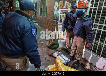 Johannesburg, Südafrika. Juli 2021. Polizisten verhaften am 11. Juli 2021 einen Protestierenden in Johannesburg, Südafrika. Die südafrikanische Polizei sagte am Sonntag, dass sie 62 Menschen in KwaZulu-Natal und der Provinz Gauteng verhaftet habe, als Menschen gegen die Inhaftierung des ehemaligen Präsidenten Jacob Zuma protestierten. Quelle: Yeshiel/Xinhua/Alamy Live News Stockfoto