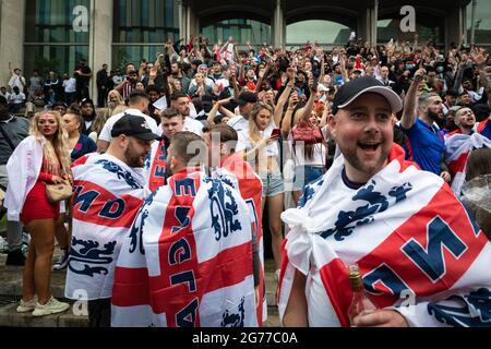 Manchester, Großbritannien. Juli 2021. Fußballfans, die mit der Flagge von St. Georges drapiert sind, kommen in die Stadt, um sich das Finale der Euro 2020 anzusehen, bei dem England Italien spielt. ÊAndy Barton/Alamy Live News Credit: Andy Barton/Alamy Live News Stockfoto