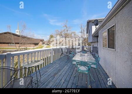 Hintertür-Veranda eines Hauses mit Blick auf einen Rasen und in der Nähe Gebäude und Straße Stockfoto