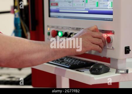 Der Bediener steuert die CNC-Laserschneidmaschine. Selektiver Fokus. Stockfoto