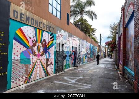 Ein Fußgänger spaziert an farbenfrohen Wandgemälden auf der Clarion Alley im Mission District von San Francisco vorbei, einer fortlaufenden Ausstellung öffentlicher Kunstwerke. Stockfoto