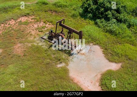 Niedriger Blick auf einen funktionierenden Ölpumpenheber, der Rohöl in Oklahoma, USA, pumpt, an einem sonnigen Tag Stockfoto