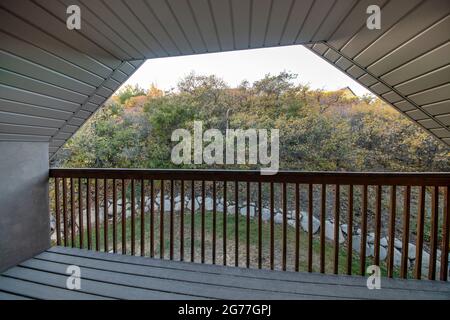 Terrasse mit Holzdielen und einer weißen Perldecke eines Halb-Hip-Dachs Stockfoto