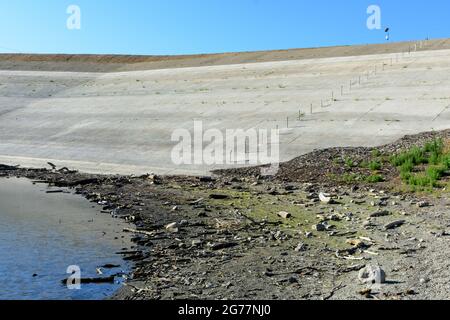 Blick auf die Betonwand des Staudamms vom schmutzigen Boden des fast getrockneten Stevens Creek Reservoirs in der San Francisco Bay Area, Kalifornien Stockfoto