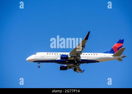 Delta Connection Embraer E175LR, ein Flugzeug von SkyWest Airlines, das sich auf die Landung am Flughafen mit eingelegtem Fahrwerk vorbereitet. Blauer Himmel - San Jose Stockfoto