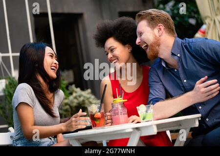 Gruppe von verschiedenen Freunden reden und Spaß im Café im Freien Stockfoto