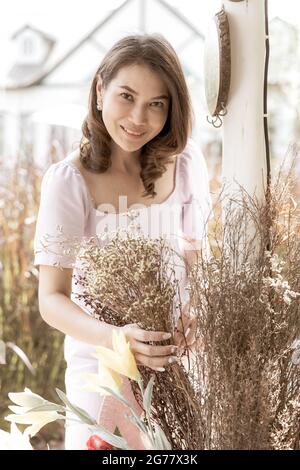 Nette schöne asiatische Frau mittleren Alters Blumengeschäft Besitzer Anordnung einer Reihe von Blumen bereit, für Kunden zu verkaufen. Foto im Filmstil verarbeitet Stockfoto