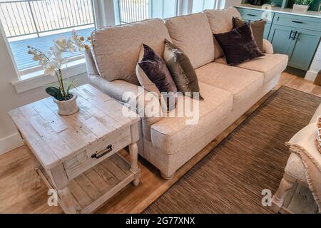 Beistelltisch und Sofa am Wohnzimmerfenster mit Blick auf die Veranda Stockfoto