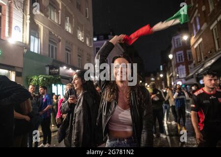 London, Großbritannien. Juli 2021. Italienische Fans feiern nach dem UEFA-Eurofinale vor einer italienischen Bar. Italiens Männermannschaft gewann am gleichen Abend im Finale der UEFA EURO 2020 im Wembley Stadium in London den Sieg über England und gewann das Turnier zum ersten Mal seit der Austragungsstätte des Wettbewerbs im Jahr 1968.Quelle: SOPA Images Limited/Alamy Live News Stockfoto