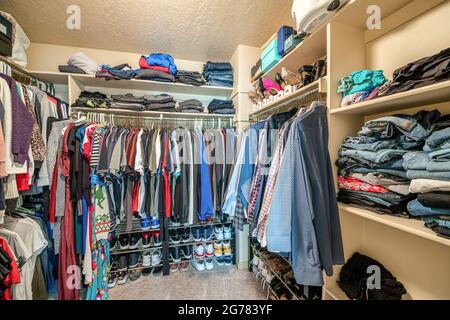 Kleiner begehbarer Schrank mit Hängestangen und Regalen Stockfoto