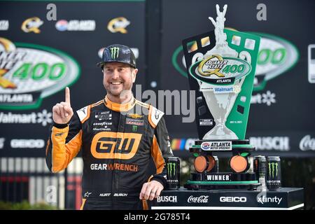 Hampton, GA, USA. Juli 2021. Der Fahrer der NASCar Cup Series, Kurt Busch, posiert mit der Trophäe auf der Siegerstraße, nachdem er den Quaker State 400 auf dem Atlanta Motor Speedway in Hampton, GA, gewonnen hat. Austin McAfee/CSM/Alamy Live News Stockfoto