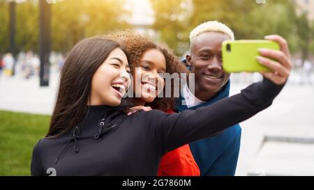 Multiethnische Freunde im Freien nehmen ein Selfie auf dem Smartphone. Diverse Gruppe Menschen Afro american Asian verbringen Zeit zusammen multirassischen männlichen weiblichen st Stockfoto