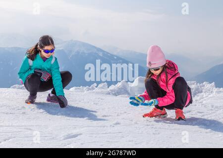 Innsbruck, Österreich - 11. April 2015 - Glückliche junge Mädchen machen im Skigebiet Nordkette in Innsbruck, Österreich, Schneeball Stockfoto