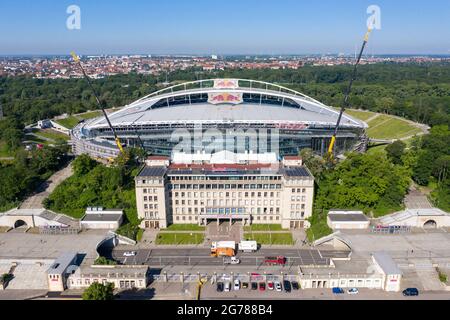 14. Juni 2021, Sachsen, Leipzig: Zwei Krane stehen in der Red Bull Arena. Das Heimgelände von RB Leipzig wird umgebaut. Die Zuschauerkapazität erhöht sich von 42,558 auf 47,069 im Stehen und Sitzen. Die Außenseite des Stadions ist von einer schalldichten Fassade umgeben. Der Damm des ehemaligen Zentralstadions, das die Arena umfasst, wurde hinter dem historischen Glockenturm aufgeschnitten, um Platz für einen neuen Eingang zu schaffen. RB Leipzig investiert bis 2022 gut 60 Millionen Euro in den Umbau. (Luftaufnahme mit Drohne) Foto: Jan Woitas/dpa-Zentralbild/ZB - WICHTIGER HINWEIS: Gemäß den Vorschriften der t Stockfoto