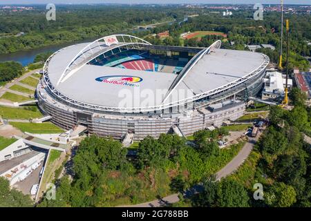 14. Juni 2021, Sachsen, Leipzig: Zwei Krane stehen in der Red Bull Arena. Das Heimgelände von RB Leipzig wird umgebaut. Die Zuschauerkapazität erhöht sich von 42,558 auf 47,069 im Stehen und Sitzen. Die Außenseite des Stadions ist von einer schalldichten Fassade umgeben. Der Damm des ehemaligen Zentralstadions, das die Arena umfasst, wurde hinter dem historischen Glockenturm aufgeschnitten, um Platz für einen neuen Eingang zu schaffen. RB Leipzig investiert bis 2022 gut 60 Millionen Euro in den Umbau. (Luftaufnahme mit Drohne) Foto: Jan Woitas/dpa-Zentralbild/ZB - WICHTIGER HINWEIS: Gemäß den Vorschriften der t Stockfoto